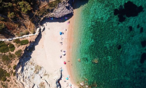 Aerial drone bird's eye view of famous clear water rocky beach of Kape in area of Legrena, Sounio, Attica, Greece.